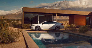 White Toyota Avalon parked outside modern home with mountains in the background